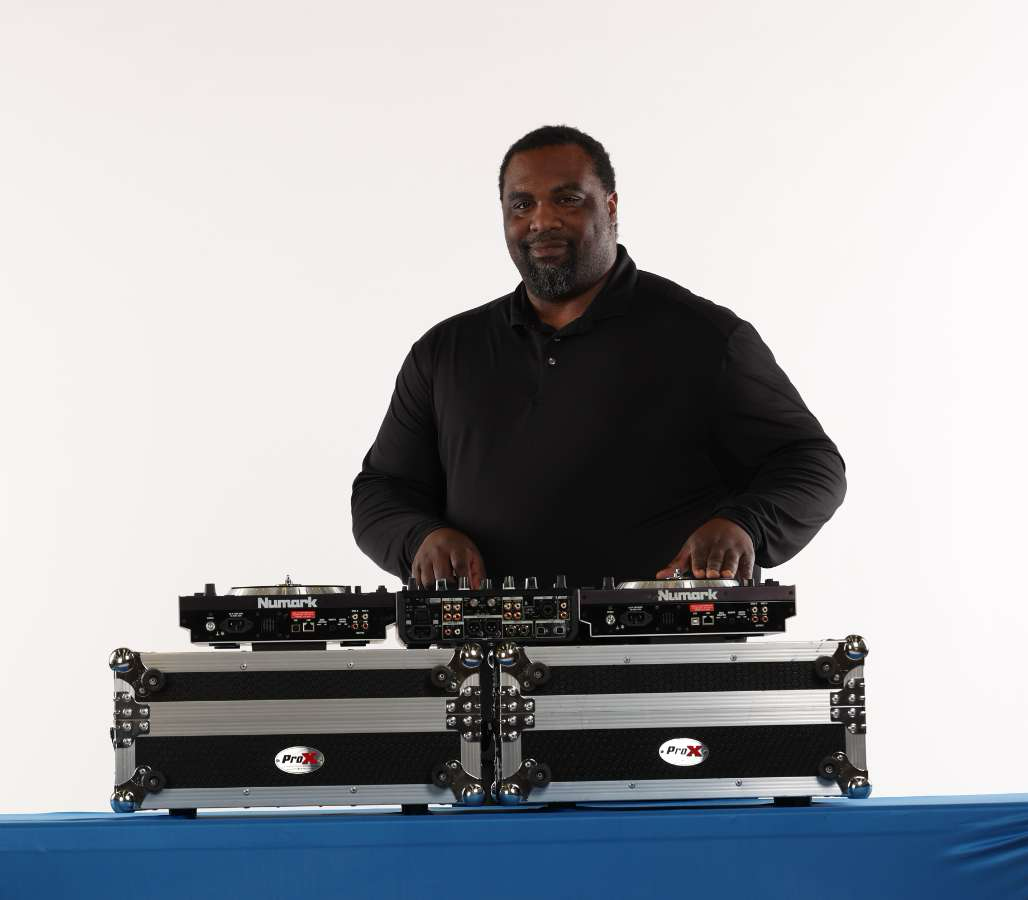 DJ SMUVE standing behind his DJ mixing equipment